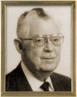Sepia-toned portrait of an elderly man wearing glasses and a suit, framed in a simple gold border.