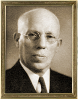 A vintage portrait of an elderly bald man wearing round glasses, dressed in a suit. The man appears thoughtful and is looking directly at the camera. His portrait is framed with a decorative gold frame set against a beige background.