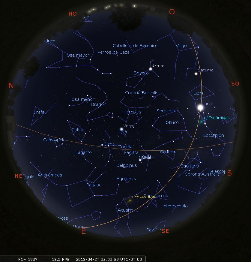 Vista nocturna del cielo estrellado mostrando múltiples constelaciones y cuerpos celestes como la Luna y Saturno, con las constelaciones delineadas y nombradas en español. Los puntos cardinales se muestran alrededor de los bordes de la imagen.