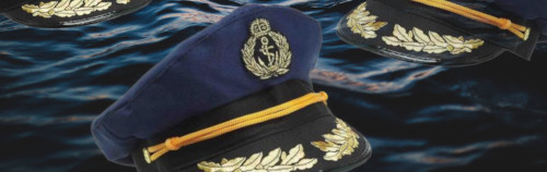 Una colección de gorras navales de color azul marino adornadas con laureles y anclas doradas bordadas, exhibidas sobre un fondo que se asemeja a la superficie de un cuerpo de agua oscuro y ondulante bajo un cielo estrellado.