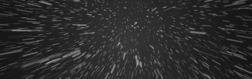 Fotografía de larga exposición que captura el movimiento radiante de las estrellas trazando estelas de luz blanca en el cielo nocturno, representando la vasta extensión del universo.