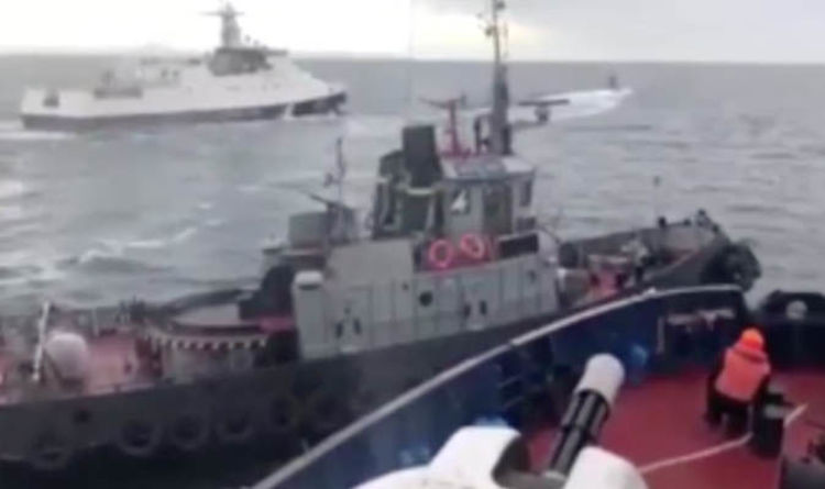 Eine maritime Szene zeigt drei Boote in unruhiger See bei bewölktem Himmel. Im Vordergrund ist ein mit bunten Rettungsringen geschmücktes Boot zu sehen, mehrere Besatzungsmitglieder in orangefarbener Sicherheitsausrüstung sind zu sehen. Im Hintergrund fährt ein weißes Boot mit elegantem Design schnell dahin.