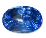 A deep blue, faceted gemstone prominently displayed with a multicolored striped background, reflecting light in various angles.