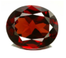 A close-up image of a dark red gemstone with numerous facets reflecting light, set against a starkly contrasting colorful digital background.