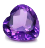 A vivid purple amethyst gemstone with a multifaceted cut, reflecting light to show various shades of purple and pink on a striped rainbow background.