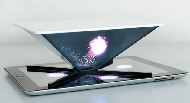 A futuristic device resembling a tablet creates a three-dimensional projection of a celestial object, glowing brightly above its mirrored surface, against a plain white background.
