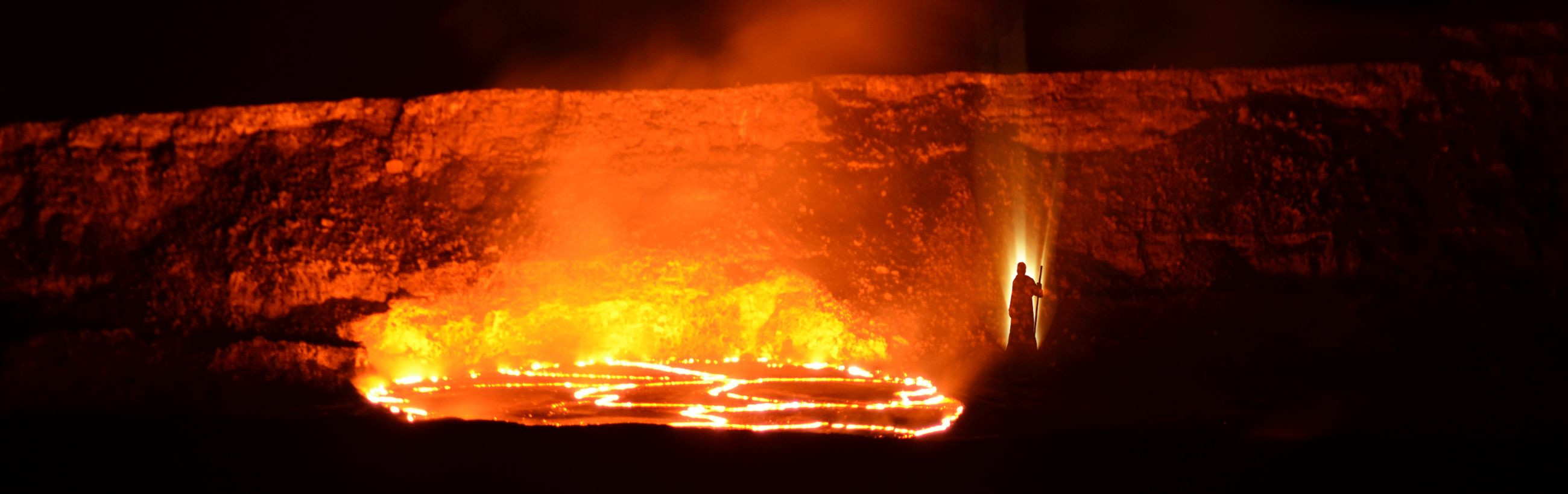 A fiery scene at night with a person illuminated by a shaft of light, standing beside a large shape of a circle made of fire on the ground, evoking themes found in the biblical description of the Mazzaroth in celestial phenomena.