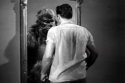 A black and white image depicting a man with his back to the camera facing a creature resembling a creature from Mazzaroth, possibly inspired by a lion, in a confined space with a door slightly ajar.