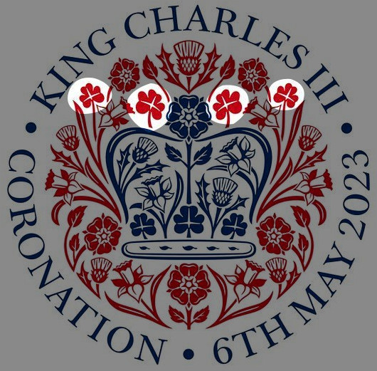 A commemorative emblem featuring a central heraldic crown surrounded by a circular array of various stylized flowers, in red and blue hues, representing an upcoming regal event. Text around the emblem indicates the event is for "King Charles III" and dates it to "6th May 2023."