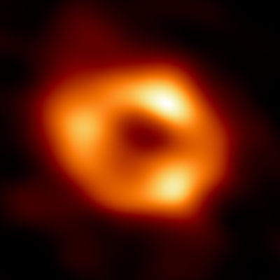 Una vívida imagen astronómica que muestra una formación de luz circular, que recuerda a los cuerpos celestes, brillando intensamente en tonos naranja y amarillo.