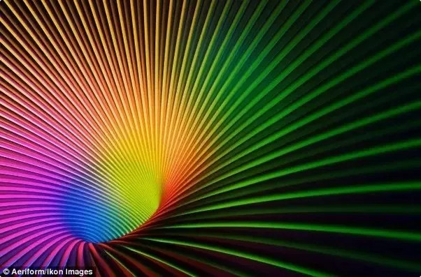 A vibrant digital artwork depicting an array of finely spaced lines that fan out from a common point, creating a spectrum of colors ranging from cool purples to warm yellows.