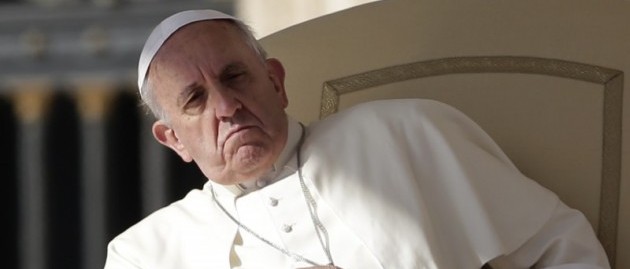 An elderly male figure dressed in a white robe and skullcap, appearing contemplative or concerned, seated in a cream chair against an architectural backdrop with columns.