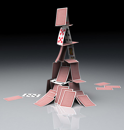 A three-dimensional rendering of a house of cards built with multiple layers. The base consists of several overlapping cards, supporting additional tiers that taper to a peak. Random cards are in mid-air around the structure, suggesting motion as if they are falling.