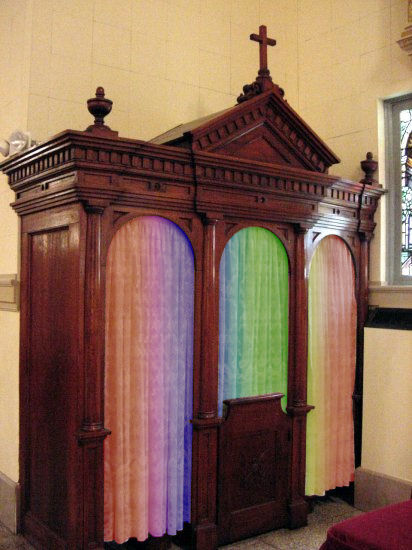 A traditional wooden confessional booth in a church adorned with a cross on top and three arched doors; each door curtain gradients from a deep purple to pink, orange, and green, evoking the diverse colors visible in the celestial sphere.