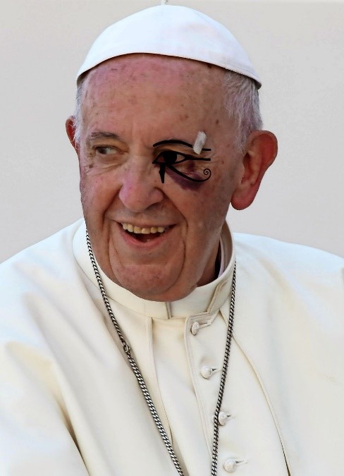 A man in a white robe with a design resembling elements of the Mazzaroth painted on his face smiles warmly.