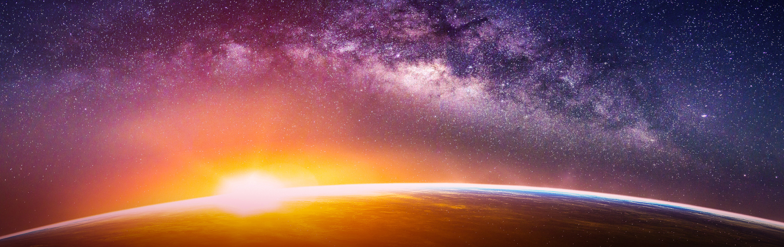 A vibrant cosmic vista showing the curvature of Earth with a sun's radiant glow creeping over the horizon. The expansive night sky is studded with stars against the canvas of the Milky Way.