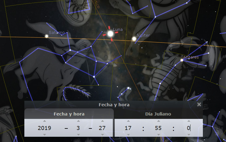 Ilustración digital que muestra un cielo nocturno estrellado con planetas y constelaciones conectadas por líneas azules. Se ven Saturno, Luna y Júpiter, así como la estrella Antares, etiquetados en el campo visual. En la parte inferior, una ventana muestra la fecha y hora exacta: 27 de marzo de 2019 a las 17:55.