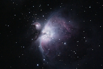 A vibrant nebula consisting of interstellar gas and dust, illuminated by starlight, displaying a complex array of colors and structures against the dark cosmic background.
