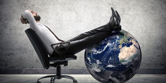 A person in business attire, balancing on a large, detailed depiction of the Earth while sitting in a modern swivel chair, leaning back with legs crossed and hands behind head in a relaxed posture.