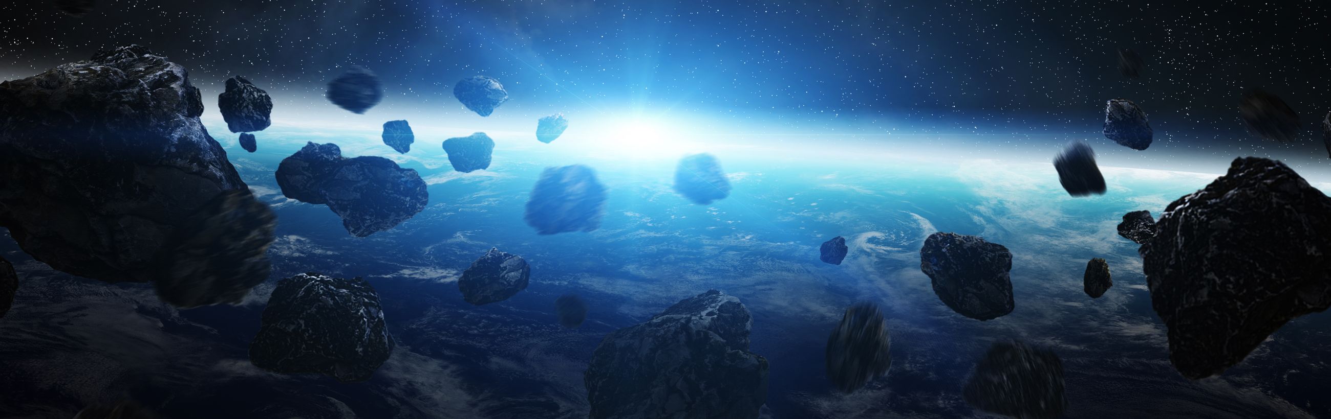 A panoramic view of Earth from space illuminated by a radiant burst of sunlight on the horizon, with multiple large asteroids floating in the foreground against a star-filled sky.